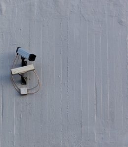 Two surveillance cameras mounted on a wall for security and safety monitoring.